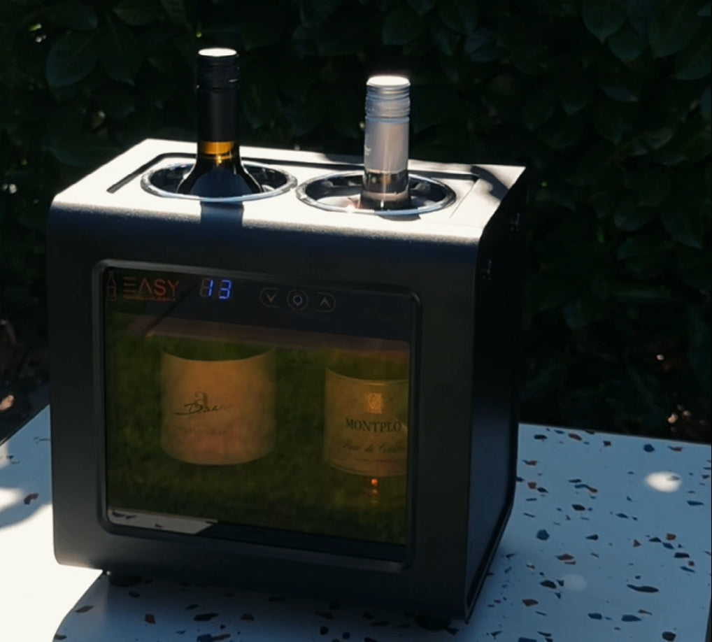 Elektrischer 2-Zonen Weinkühler für zwei Weinflaschen steht in der Sonne auf einem Terrassentisch