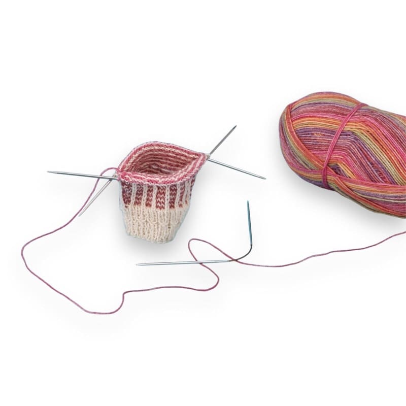 Bunte gestrickte Socke mit Nadeln und Garn von addi Crasy Trio Socken-Stricknadeln