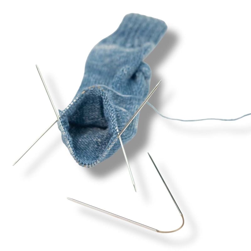 Blauer gestrickter Socken mit Nadeln von Addi Crasy Trio für Sockenstricken